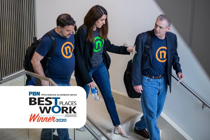 Nelnet is a Top Workplace in Rhode Island - three Nelnet associates wearing Circle N t-shirts walk side by side through an office