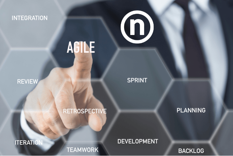 Agile Framework at Nelnet - A man in a suit points to the word Agile on a touchscreen